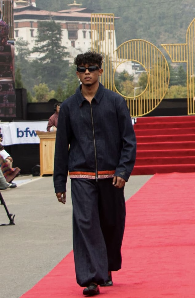 This denim two-piece combines old denim garments with leftover textile pieces from Bhutanese tailors. The pants feature denim panels made from a used dress sewed into the sides, while fragments of tailor’s leftovers are added, giving the clothes a touch of the beautiful bhutanese traditional weaving culture.